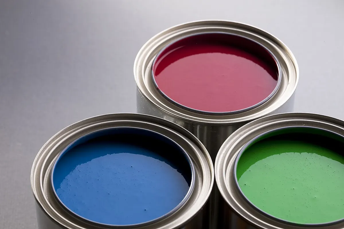 Latas de pintura abiertas en distintos colores