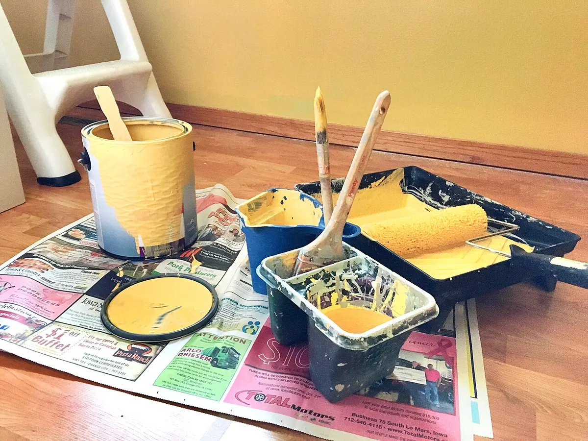 Latas, bandeja y rodillos listos para pintar un ambiente